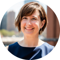 Headshot of a smiling client with short brown hair outdoors